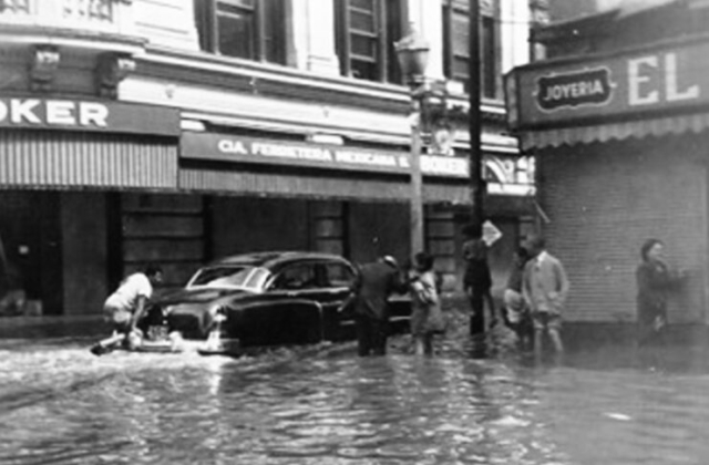 Persona empujando un automóvil en la inundación